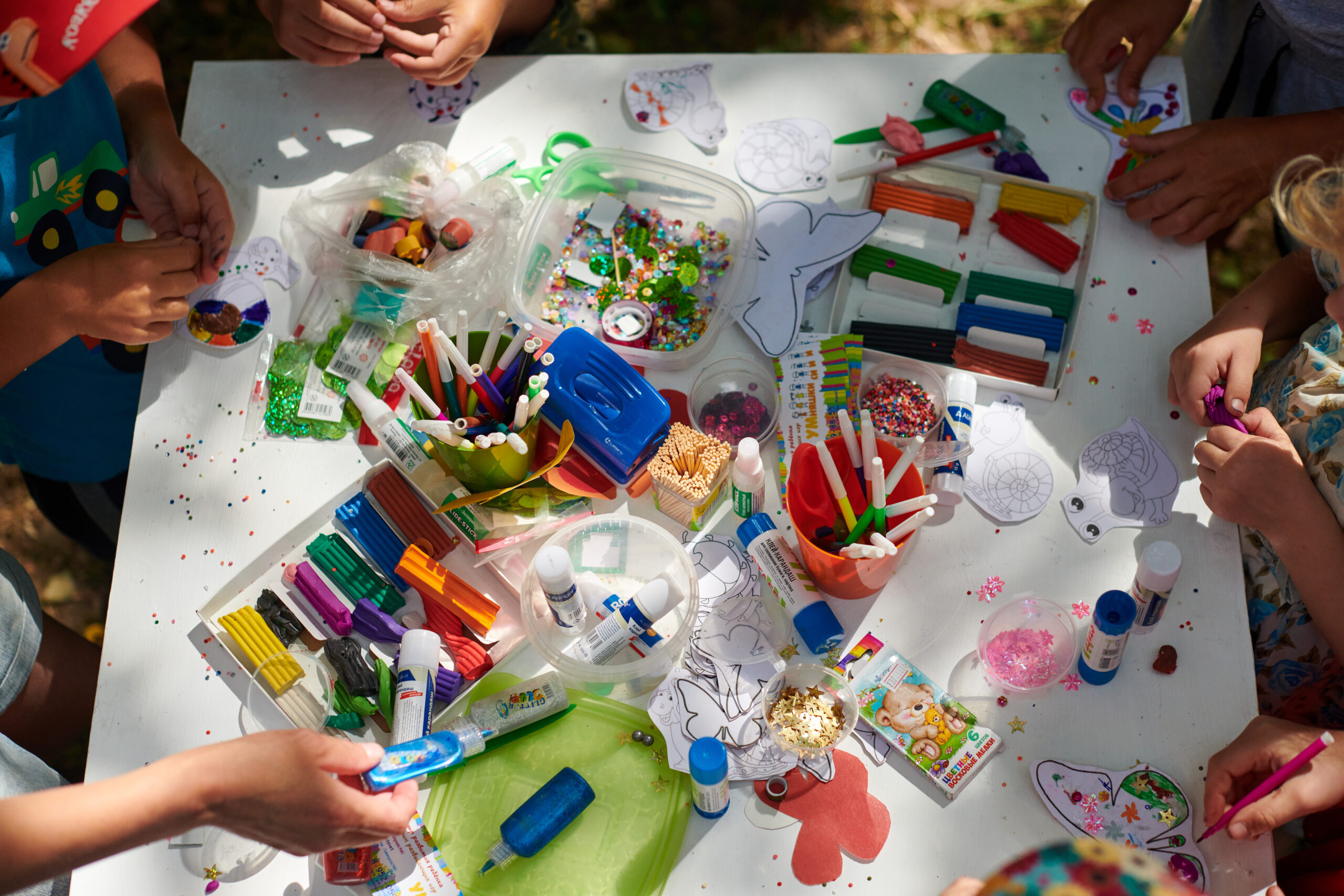 Children paper crafting outdoors with our leaders during a creative activity