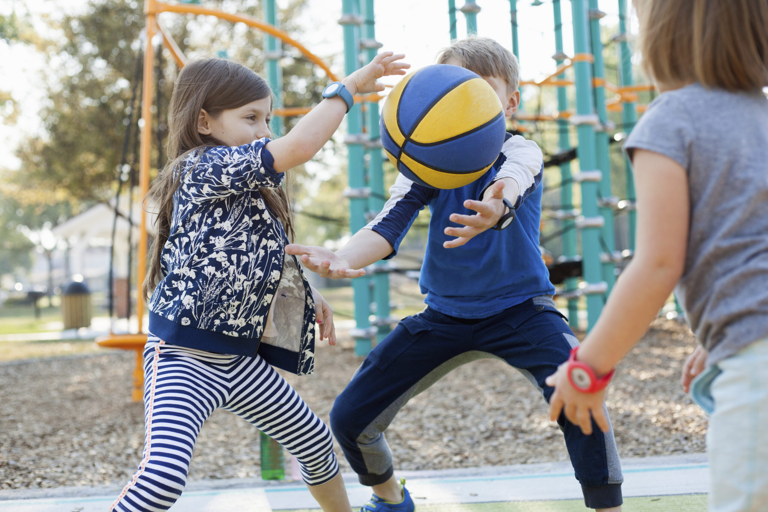 Children playing basketball outdoors during a holiday club sports session